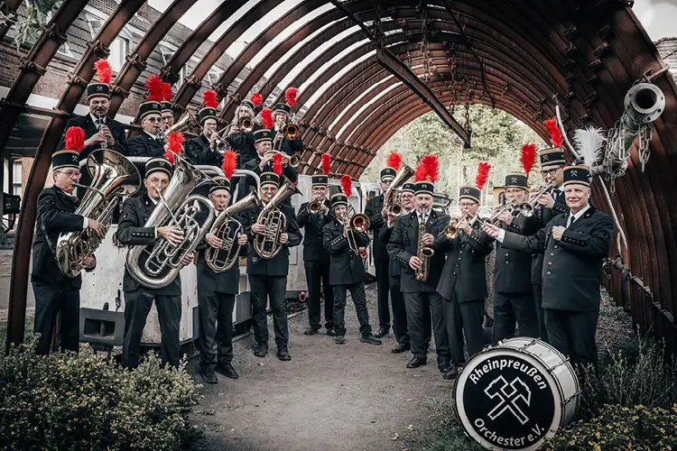 Auf diesem Bild sehen Sie eine Kapelle in traditioneller Kleidung mit vielen Instrumenten spielend