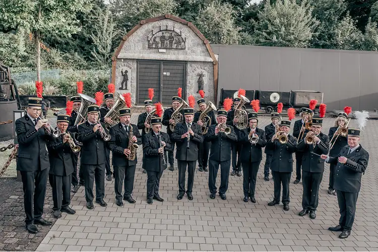 Auf diesem Bild sehen Sie eine Kapelle in traditioneller Kleidung mit vielen Instrumenten spielend