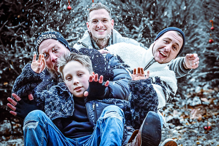 Auf diesem Bild sehen Sie eine fröhliche Familie auf einem Schlitten im Schnee